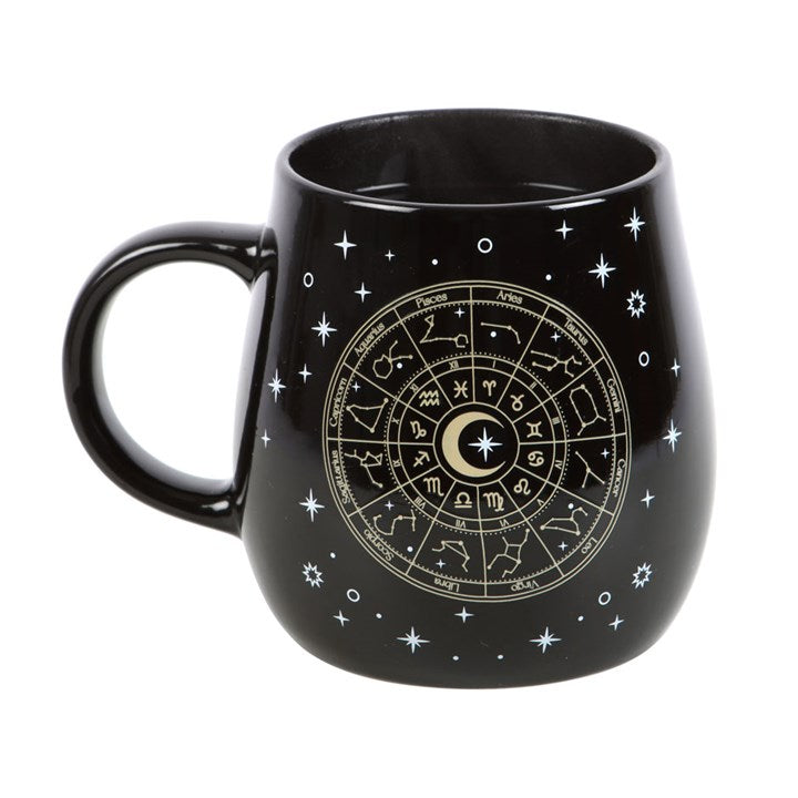 Black heat-changing celestial mug featuring a gold Astrology Wheel design surrounded by twinkling stars. The design appears when a hot beverage is poured in. 500ml capacity, dishwasher safe, not microwave safe