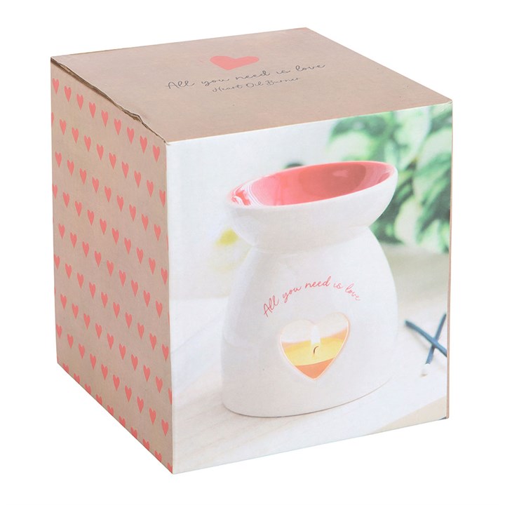 Ceramic wax melt burner with 'All You Need Is Love' text, featuring a heart-shaped cutout glowing with a tealight candle and a red interior bowl. Perfect for home fragrance lovers to create a cozy and romantic ambiance