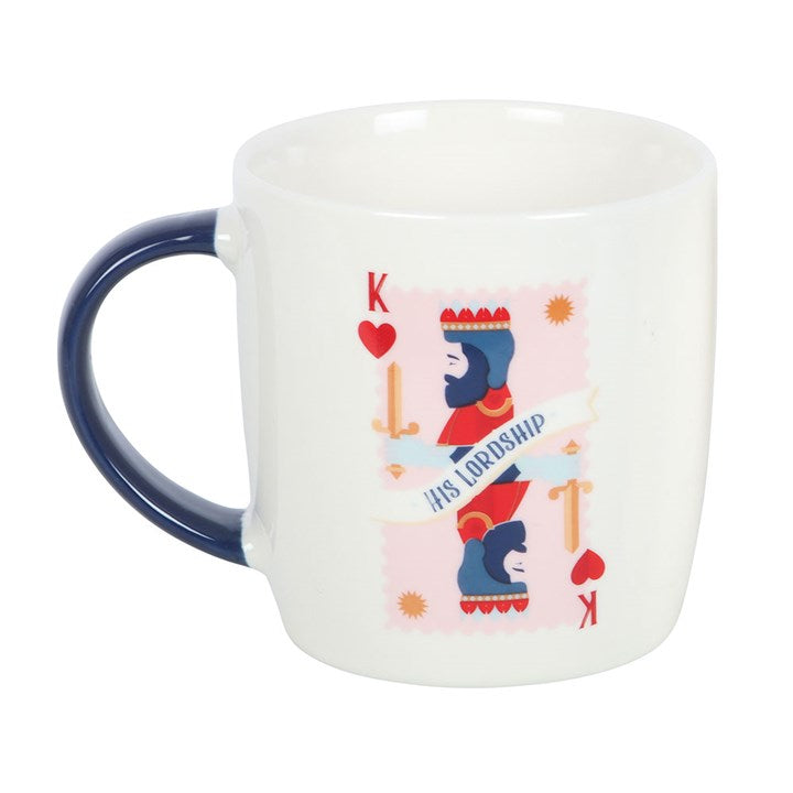 A white ceramic mug with a navy handle, featuring a king of hearts playing card illustration and the phrase “His Lordship.” The mug sits on a round white tray, offering a refined and playful design perfect for the royal gentleman in your life.