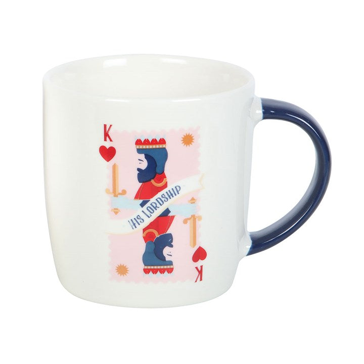 A white ceramic mug with a navy handle, featuring a king of hearts playing card illustration and the phrase “His Lordship.” The mug sits on a round white tray, offering a refined and playful design perfect for the royal gentleman in your life.