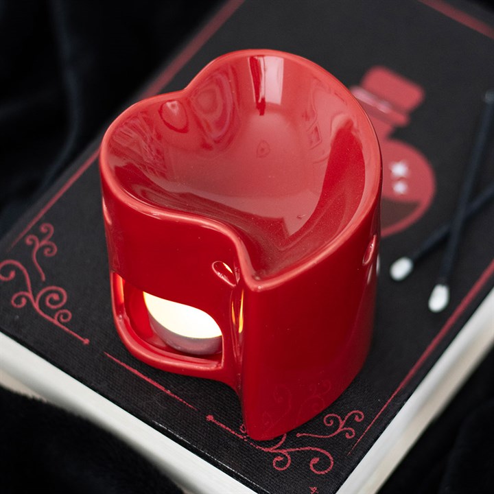 Red ceramic heart-shaped oil burner and wax warmer, perfect for creating a romantic ambiance with essential oils or wax melts. Stylish and functional home fragrance accessory.