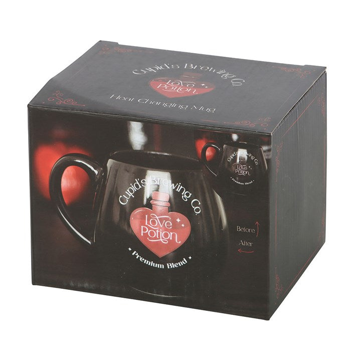 Black ceramic Love Potion heat change mug featuring 'Cupid's Brewing Co.' design with a heart-shaped potion bottle graphic that changes color when filled with a hot beverage.