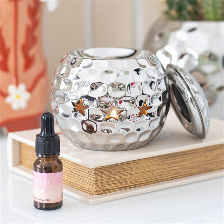 Silver disco ball oil burner with a hammered metallic finish and star-shaped cutouts, perfect for creating a stylish and modern ambiance with wax melts or essential oils