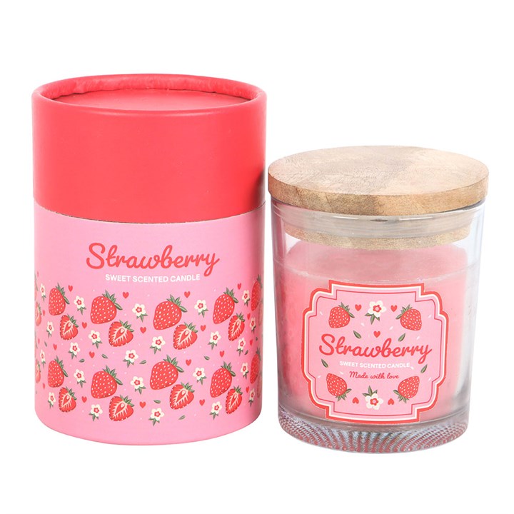 A strawberry-scented candle in a transparent glass jar with a pink floral and strawberry print label