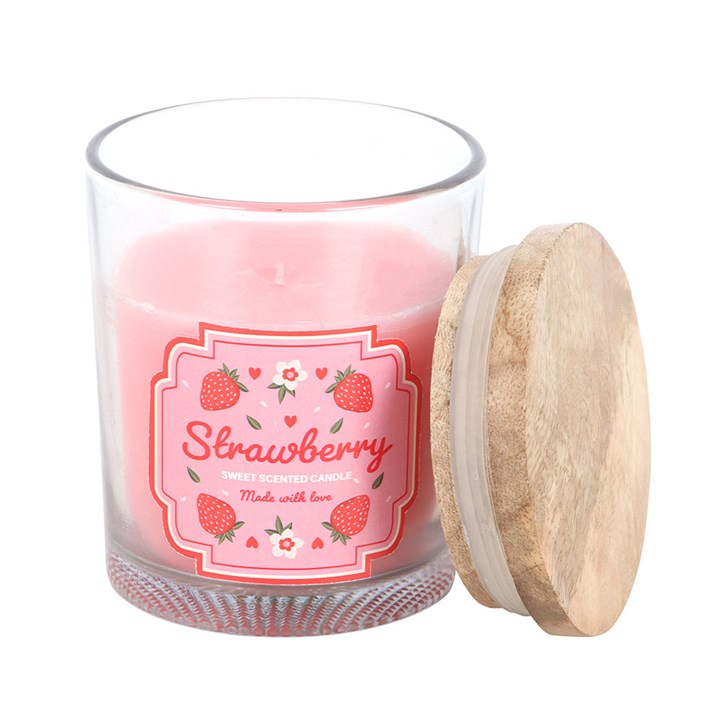 A strawberry-scented candle in a transparent glass jar with a pink floral and strawberry print label