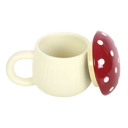 A novelty ceramic mug shaped like a mushroom, with a cream-colored base and a glossy red lid topped with white polka dots. The design mimics a toadstool, giving it a playful, whimsical look.
