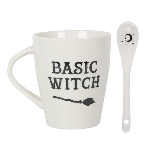 White ceramic mug with 'Basic Witch' text and a broom design, accompanied by a matching spoon featuring a crescent moon and stars. Dishwasher and microwave safe, perfect for witchy and Halloween lovers.