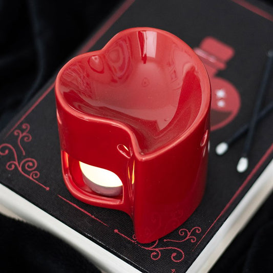 Red ceramic heart-shaped oil burner and wax warmer, perfect for creating a romantic ambiance with essential oils or wax melts. Stylish and functional home fragrance accessory.