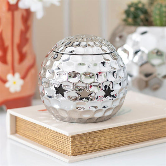 Silver disco ball oil burner with a hammered metallic finish and star-shaped cutouts, perfect for creating a stylish and modern ambiance with wax melts or essential oils