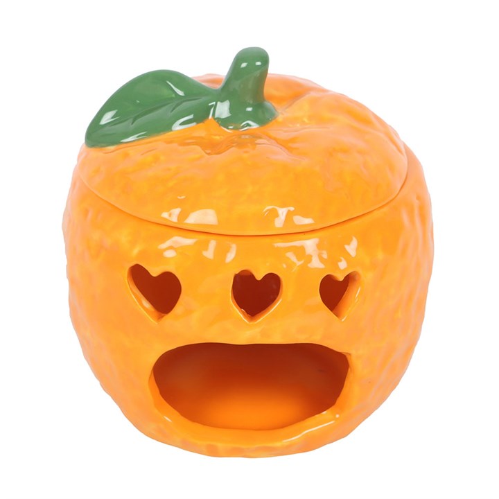 A ceramic orange-shaped oil burner with a glossy finish, featuring cut-out heart shapes that allow the light from a tealight candle to shine through.