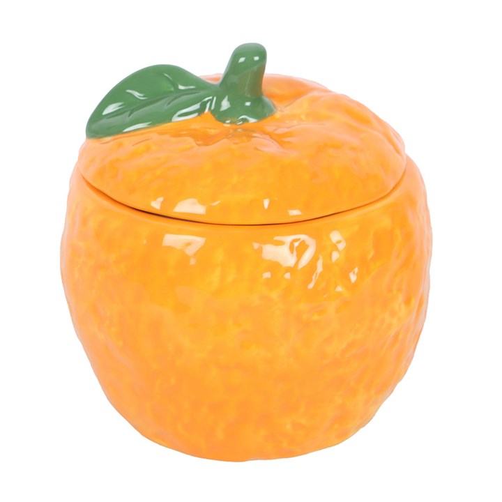 A ceramic orange-shaped oil burner with a glossy finish, featuring cut-out heart shapes that allow the light from a tealight candle to shine through.