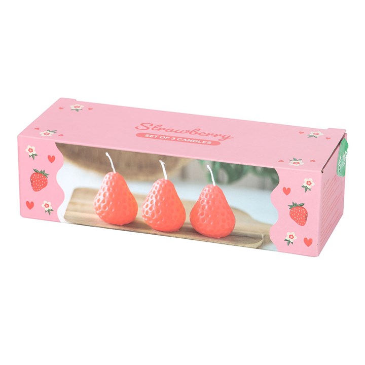 A set of three unscented, strawberry-shaped candles with a textured surface, placed on a wooden board. The candles have a vibrant red-orange hue and white wicks, adding a decorative touch