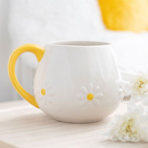 White ceramic mug with embossed daisy flower details and a vibrant yellow handle, perfect for adding a touch of cheer to your coffee or tea moments
